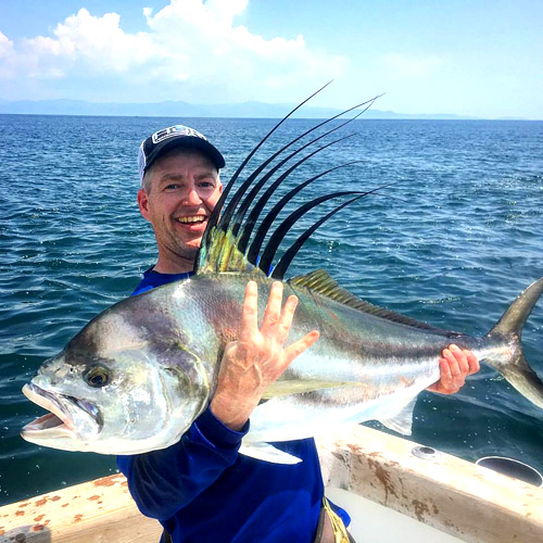 man with a rooster fish on a Costa Rican fishing charter