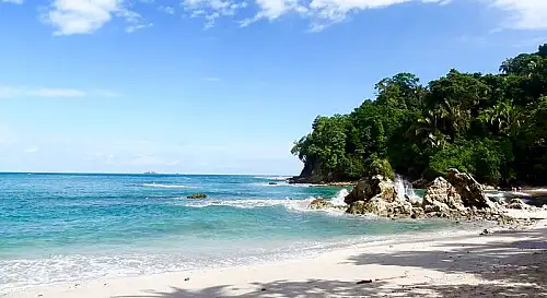 "Reef-safe sunscreen and a quick-dry towel on the white sands of Playa Manuel Antonio"