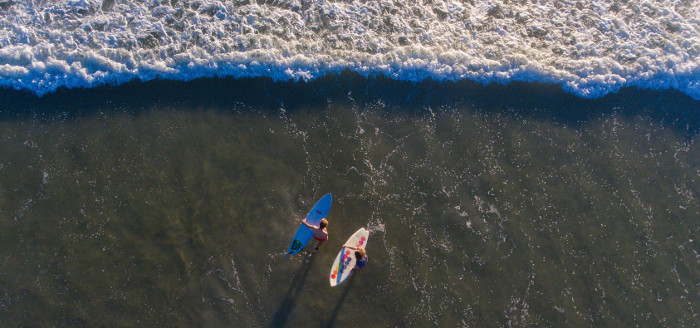 Two guys surfing on a beach